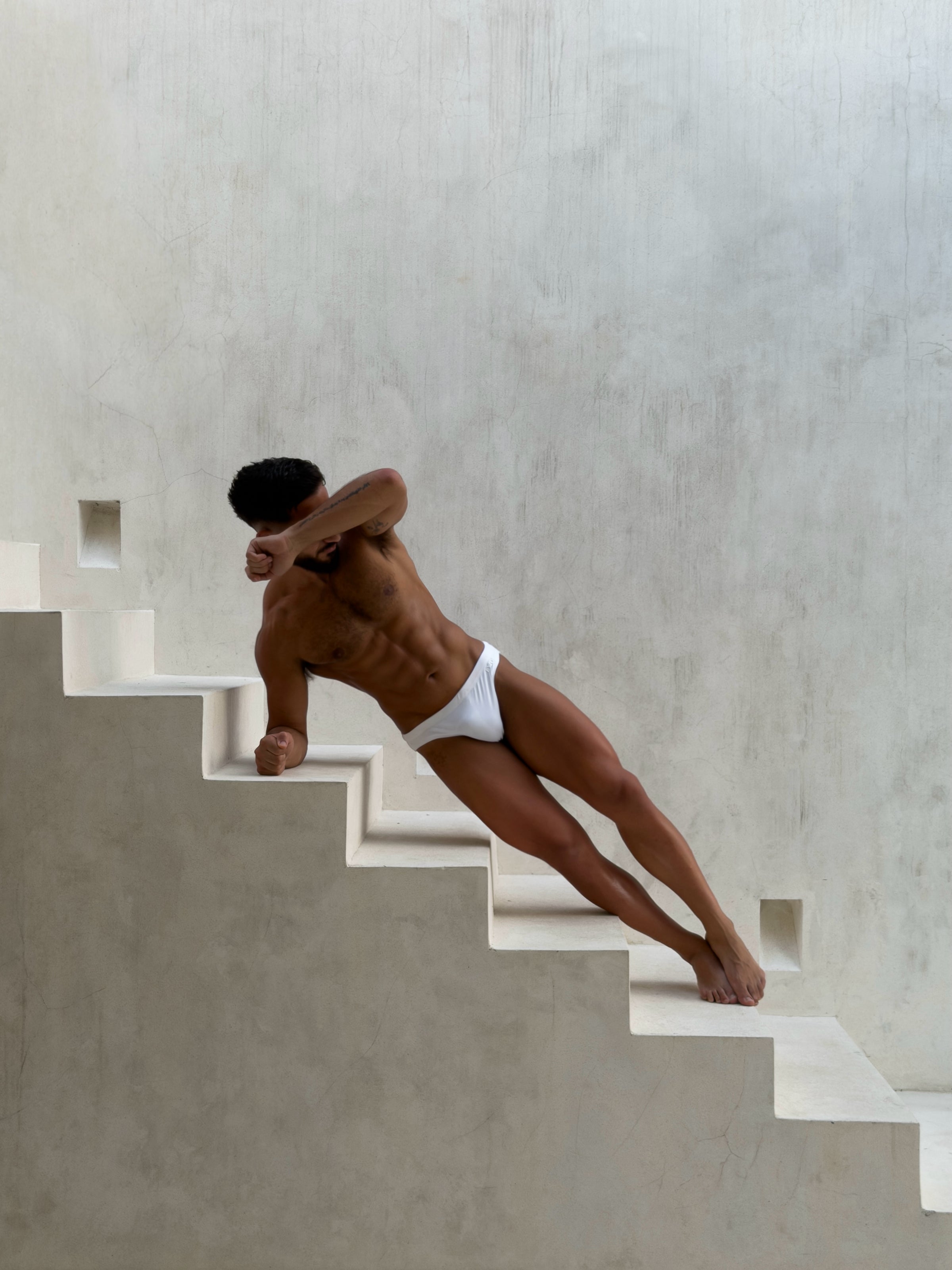 BYLOS swim briefs on plaster stairs
